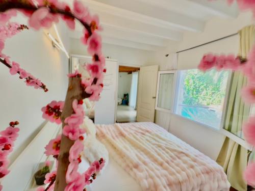 伊维萨镇Casa Klod Ibiza的一间卧室,床上有粉红色的鲜花