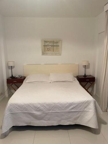 布宜诺斯艾利斯Un bonito lugar en el centro de Buenos Aires的卧室配有一张白色床、两个床头柜和两盏灯。