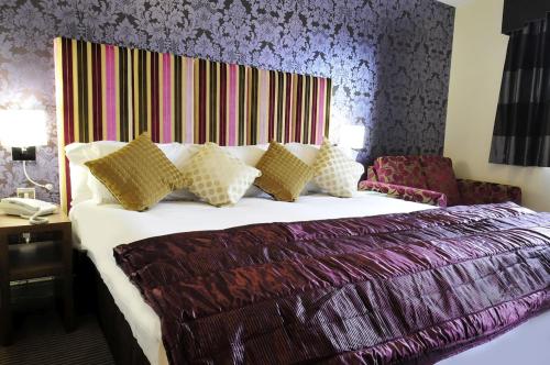 北安普敦霍平野兔酒店的一间卧室配有一张大床和色彩缤纷的床头板