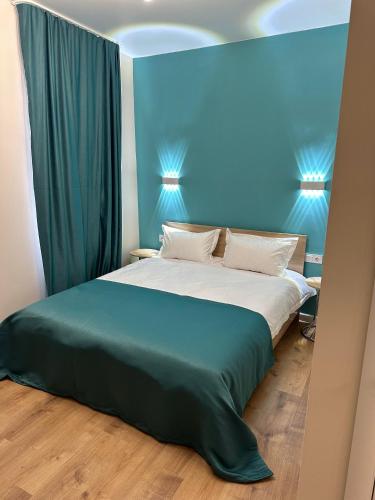 阿拉木图Отель ЭРА的一间卧室设有一张蓝色墙壁的大床
