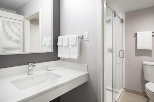 福斯特城圣马特奥福斯特城万怡酒店的白色的浴室设有水槽和淋浴。