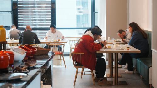 张家界Zhangjiajie Hero Boutique Hotel的一群坐在餐厅桌子上的人
