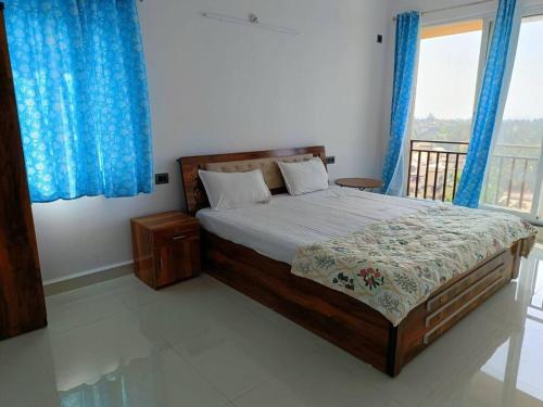 波戈马洛Zanita Heights Seaview Apt的一间卧室配有一张带蓝色窗帘的大床