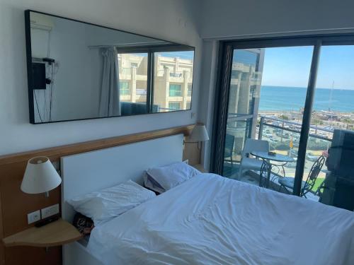 荷兹利亚Bמלון דירות אוקיינוס במרינה דירות עם נוף לים的一间卧室配有一张床,享有海景