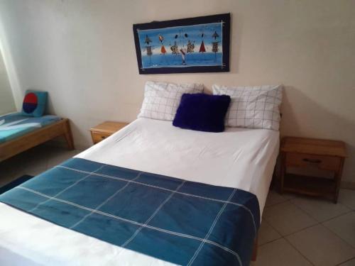 RufisqueRésidence Keur Fleurie Sénégal的一间卧室配有一张带蓝色和白色枕头的床