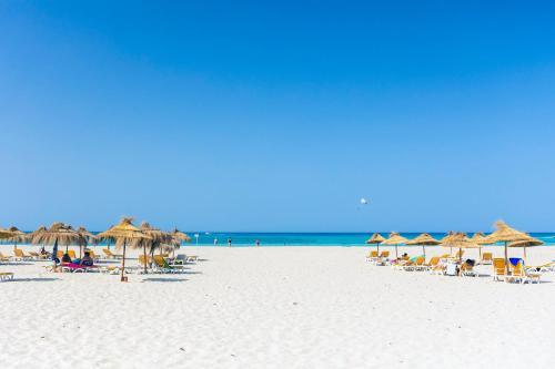 特里法TMK Marine Beach - All Inclusive Seafront resort的海滩上设有遮阳伞和椅子,还有大海