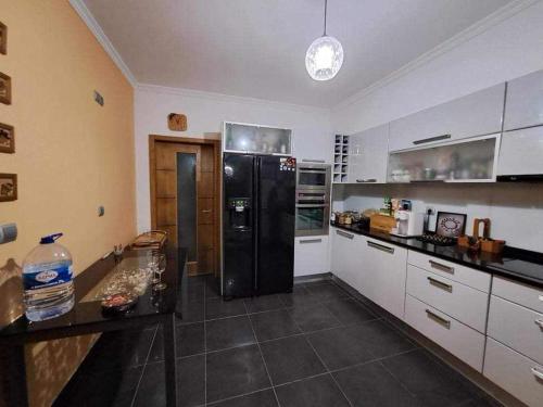 里韦拉布拉瓦Sea View House的厨房配有黑冰箱和白色橱柜。
