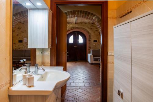 布拉卡尼Le Gerlette - La Stalla的一间带水槽和镜子的浴室以及走廊