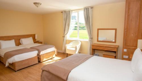 特里姆Knightsbrook Hotel Courtyard Accommodation的酒店客房设有两张床和窗户。