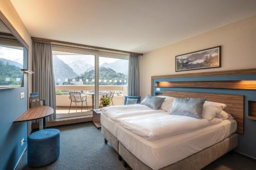 因特拉肯瑞士品质都市酒店的酒店客房设有一张床和一个大窗户