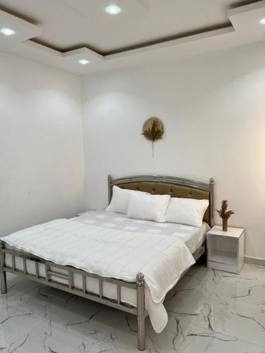 ThièsRésidence Mounir的一间卧室配有带白色床单和枕头的床。