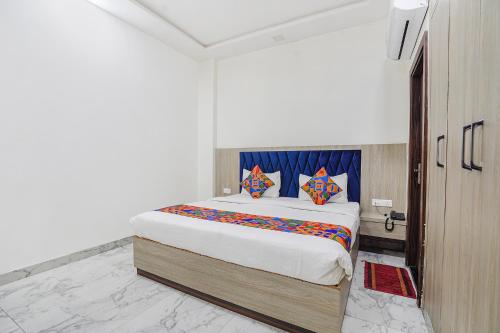 TājganjFabHotel Taj Avenue的一间卧室配有一张带色彩缤纷枕头的大床
