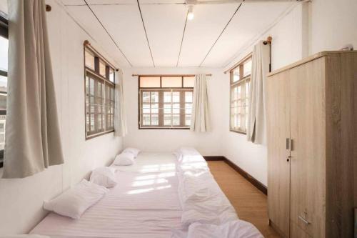 清刊บ้านพักเหมาหลังเชียงคาน ฮักเลย ฮักกัญ โฮมสเตย์ 1 - ຊຽງຄານ ຮັກເລີຍ ຮັກກັນ ໂຮມສະເຕ1 -Chiang Khan Hugloei HugKan Homestay1的带3张床的窗户客房