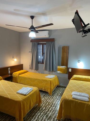 拉班达Hotel Nuevo Trento的酒店客房设有三张床和吊扇。