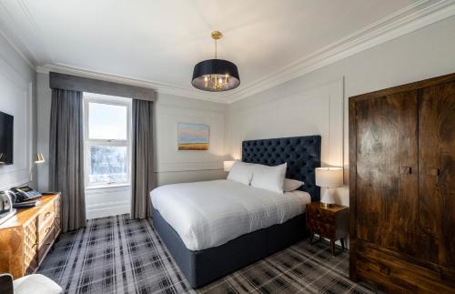 纽堡Udny Arms Hotel的一间卧室配有一张床、一个梳妆台和一扇窗户。