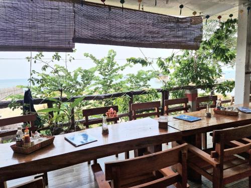 富国Butterfly Rose Beach Resort Phú Quốc Francophone的一间带桌椅的用餐室和大窗户