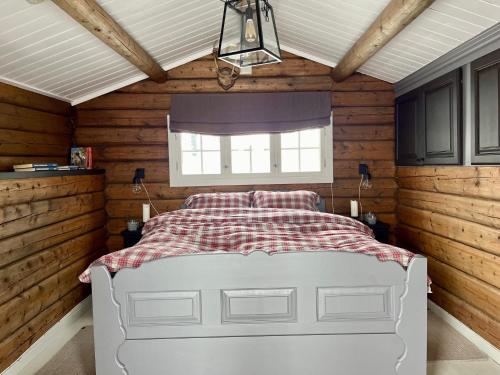 LykkjaCosy and Quiet Cabin with Sauna close to Hemsedal的一间设有白色床的卧室,位于带木墙的房间