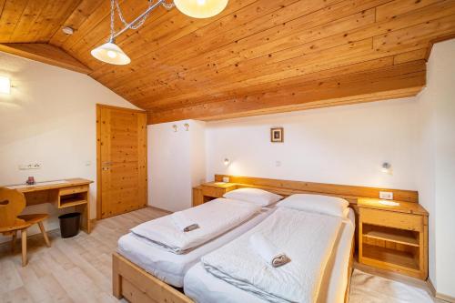 FleresGartnerhof Apt Sonnenblume的一间卧室设有两张床和木制天花板