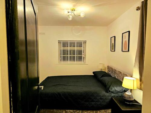 布里真德Modern & Cosy 1 bedroom flat的一间卧室设有一张黑色的床和一个窗户。