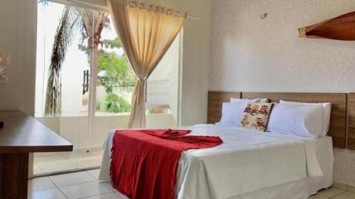 马瑙斯HOTEL DA MARGEM的一间卧室配有一张床铺,床上铺有红色毯子