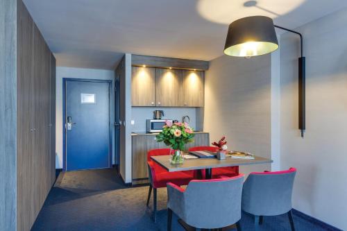 列日Van der Valk Hotel Liège Congres的厨房配有红色椅子和蓝色门