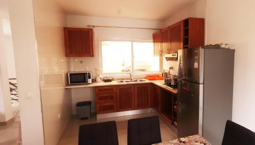 普拉亚Miras Guest House的厨房配有木制橱柜和不锈钢冰箱。