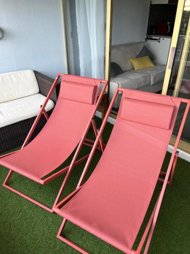 卢贝新城4 pers , 100m de la plage marina baie des anges French Riviera的客厅配有两张红色折叠椅和一张沙发