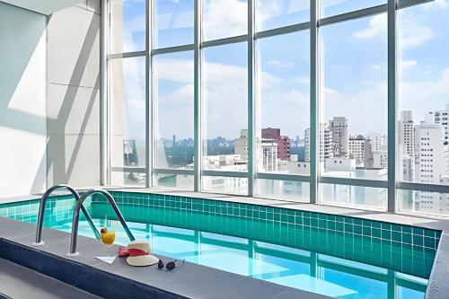 圣保罗Get a Flat 701 - Ibirapuera -Jardins的一座带窗户的大型建筑中的游泳池