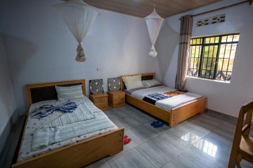 KabarondoAkagera Neighbors的一间卧室设有两张床和窗户。