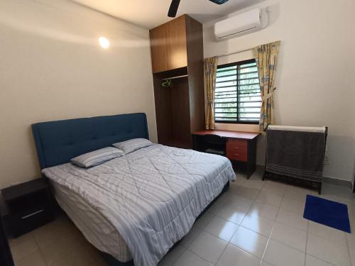 浮罗山背Lim Garden Homes的一间卧室配有一张床、一张书桌和一个窗户。