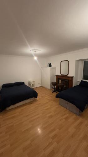都柏林Huge Family Room Clontarf House-4的一间卧室设有两张床,铺有木地板