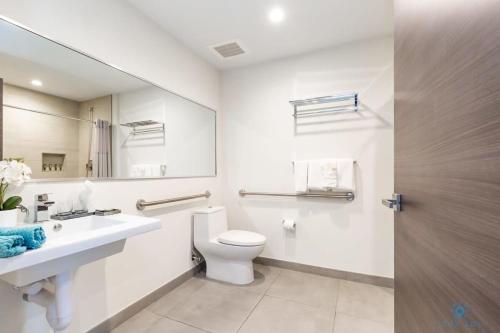 好莱坞NEW Beachfront Condo ROOFTOP infinity POOL的一间带卫生间、水槽和镜子的浴室