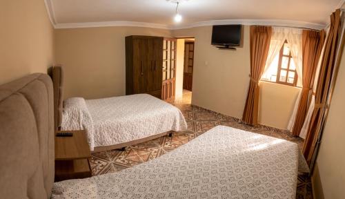 苏克雷Casa Martinez的酒店客房设有两张床和电视。
