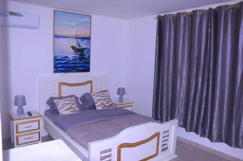 利伯维尔Résidence reine lumière的一间卧室,配有一张床和一幅小船画