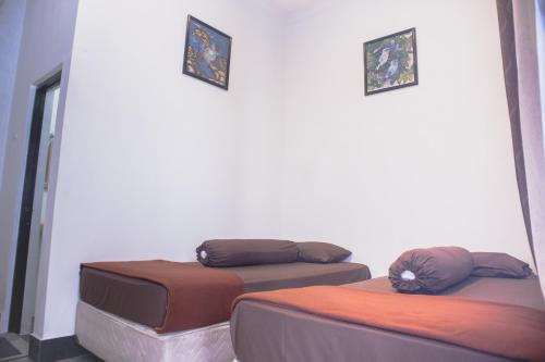 TimuranKAZAIN HOTEL的墙上有两张照片的房间的两张床