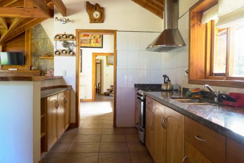 拉安戈斯图拉镇BOG La Florcita - hermosa cabaña familiar的厨房配有水槽和炉灶