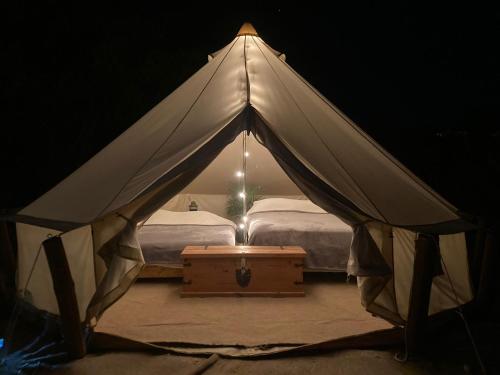 El SargentoGlamping 3 Idiomas的配有一张床和一张桌子的白色帐篷