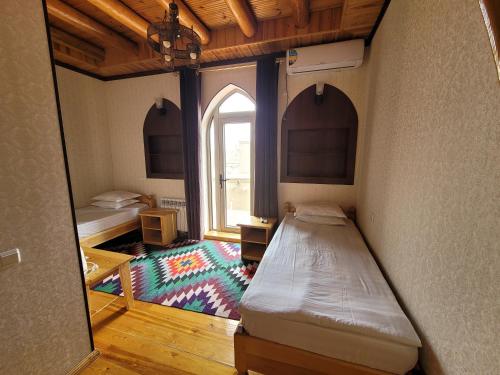 希瓦Khiva Siyovush Hotel的小房间设有床和窗户