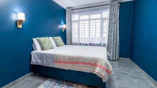 尼耶利The Fairway Residence的蓝色的卧室设有床和窗户