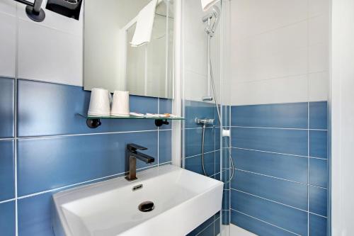 巴黎阿尔通纳酒店的浴室设有白色水槽和蓝色瓷砖