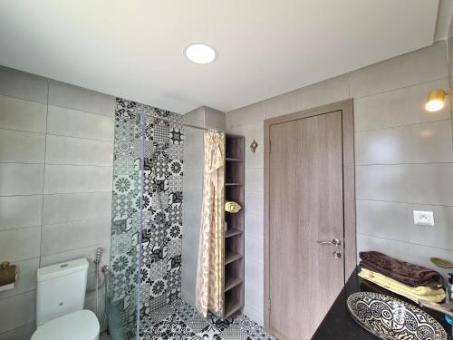 卡博尼格洛Superbe appartement avec une vue panoramique sur piscine的一间带卫生间和玻璃淋浴间的浴室
