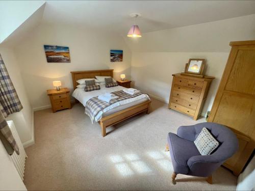牛顿莫尔Sherrabeg Cottage的一间卧室配有一张床和一把椅子