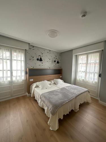 塔索内斯Hotel El Pescador的一间卧室设有一张大床和两个窗户。