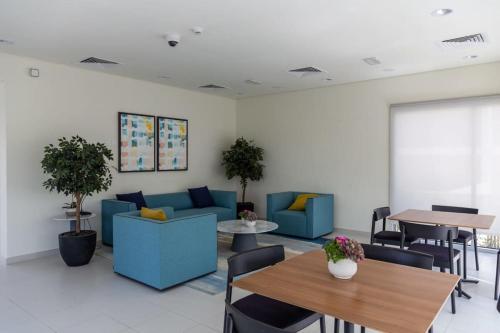 迪拜Frank Porter - Urbana II的一间设有蓝色沙发和桌子的等候室