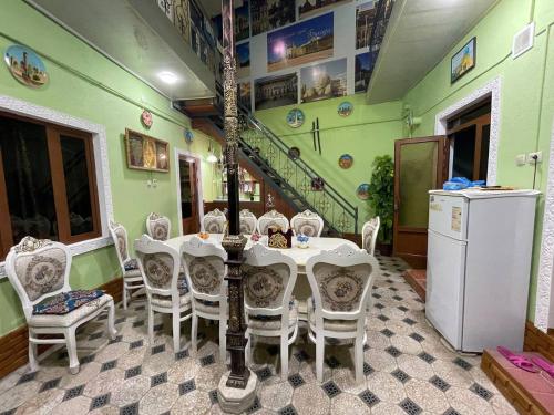 布哈拉Hotel Uncle Kolya Boutique的一间带桌椅和楼梯的用餐室