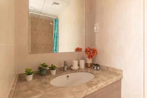 迪拜Frank Porter - Canal Residence的浴室设有水槽、镜子和植物