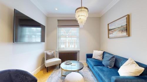 伦敦The Wimpole IX - 1 bed flat的客厅配有蓝色的沙发和桌子