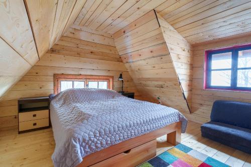 莫克拉戈拉Brvnara Iverak的小木屋内一间卧室,配有一张床和一张沙发