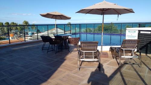 嘎林海斯港Maraca Beach的庭院配有桌椅和遮阳伞。