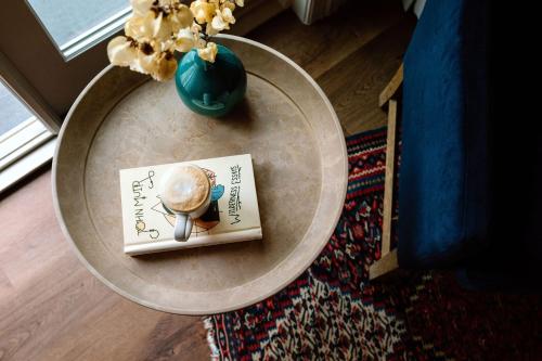 索诺玛埃多拉多酒店的一张桌子,上面有一本书和一个花瓶